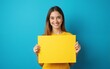 © si - Photo portrait of attractive young woman compare hold look empty space dressed stylish yellow clothes isolated on blue color background. High quality
