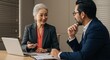 © Mauricio - Senior asian businesswoman talking with male colleague in office