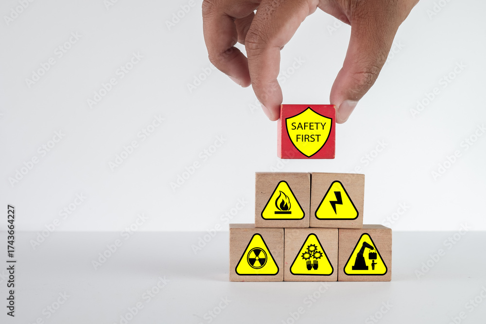 Occupational health and safety (OHS) concept. A hand places a 'Safety ...