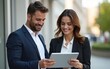 © li - Handsome man and beautiful woman as business partners using digital tablet outdoor. High quality
