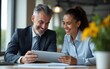 © li - Professional business people, two happy busy mid age business man and young woman executives partners team working together consulting and collaborating sitting in company office using digital tablet.
