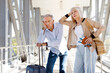 © Anastasiya - Tired mature couple waiting at airport with passports and luggage, showing boredom