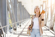 © Anastasiya - Happy mature woman holding passport and ticket at airport corridor with luggage