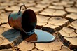 © wichit - Rusty pail spills dark liquid onto cracked earth, a visual metaphor for resource depletion and environmental fragility.
