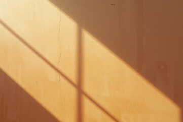 Wall Mural - Texture of a weathered wall with shadows and cracks, illuminated by sunlight. Warm beige to orange gradient showcasing natural light effects. Abstract backdrop with space for text.