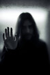 © Rohit k  - Mysterious figure with long hair reaching out through foggy glass in dimly lit setting during late evening