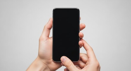 Mobile phone held by human hand, shows blank screen. Hand is using mobile phone, interacting with device in studio environment, ready for app presentation.