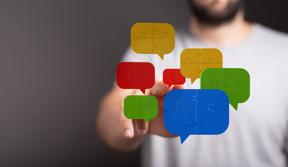 Conceptual communication image showing a man connecting jigsaw puzzle speech bubbles, symbolizing connection and teamwork in discussions.