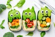 © dashtik - Creative kids lunch box with dinosaur-themed sandwiches and fresh vegetables