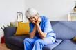 © Xavier Lorenzo - Thoughtful senior female doctor sitting on sofa after hard work day in hospital. Wellness and healthcare lifestyle concept
