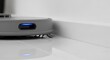 © Octopus16 - Robotic Vacuum Cleaner Moving Along White Floor Near Wall in Modern Minimalist Home
