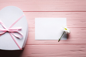 Wall Mural - Blank card, gift box and flower on pink wooden table, flat lay