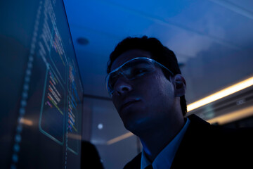Two software developers collaborating at night, focusing on code review and debugging process on a computer screen, representing teamwork, innovation, and modern software development workflow.