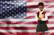 © New Africa - Little girl with backpack and notebooks against flag of USA. Language school