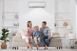 © New Africa - Happy family enjoying comfortable temperature in room with air conditioner