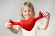 © lookbook - Front view. A cute little girl is holding a soft toy in the shape of a heart