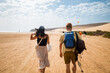 © Mal de Ojo Studio/Stocksy - Hikers Strolling Along Sandy Beach