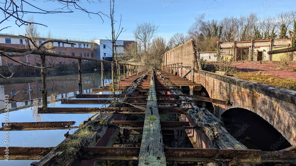 Abandoned wooden railway bridge, river. Derelict rusted rail tracks ...