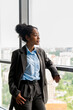 © Basil Pind/Stocksy - Businesswoman Gazing Out Hotel Window Overlooking City