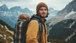 © Studicon - A man with long brown hair and a beard is smiling at the camera while wearing a mustard-yellow jacket and a brown beanie. He is carrying a large backpack and standing in front of a mountain range.