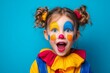 © raquel - Excited girl in clown costume with colorful makeup on blue background