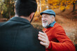 © Halfpoint - Grandad and grandson sitting on bench in park and hugging.