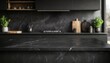 © Studicon - The image shows a black marble countertop in a modern kitchen with dark cabinetry and a blurred background of kitchen utensils and plants.