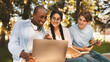 © Prostock-studio - Excited international students studying in park, enjoying the results of their job, looking at laptop screen and smiling, sitting together on bench in campus