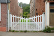 © Studio KME/Stocksy - White Wooden Gate Between Brick Houses