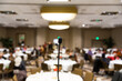 © Holly Clark/Stocksy - Microphone in front of a room at the beginning of an event