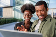 © Jovo Jovanovic/Stocksy - Two smiling people looking at a laptop outdoors.