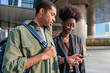 © Jovo Jovanovic/Stocksy - Two people looking at a phone outside a building.