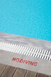 © Sonja Lekovic/Stocksy - Turquoise swimming pool edge and no diving sign