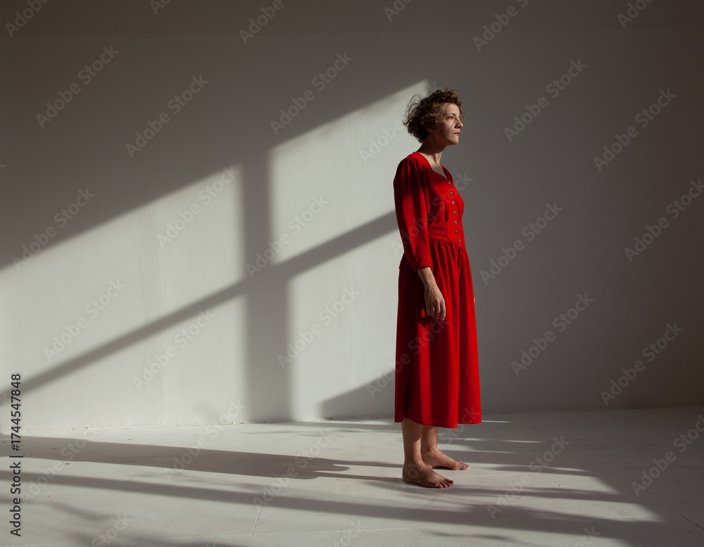 A woman in the red dress dancing in the sunny white space Stock Photo ...