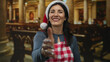 © Krakenimages.com - Woman wearing santa hat and checkered apron extends hand for handshake in building; holiday warmth community welcome.