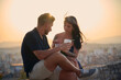 © Cavan Images - Couple enjoying romantic date with drinks at sunset