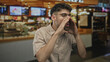 © Krakenimages.com - Young hispanic bearded man cups hands to mouth in building; excitement communication attention energy.