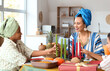 © Pixel-Shot - African-American mother with her children and candles having dinner at home. Kwanzaa celebration