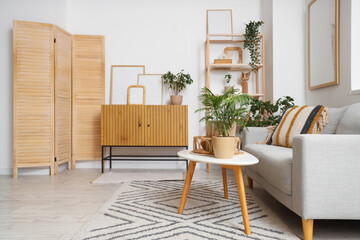 Wall Mural - Cozy sofa, coffee table and chest of drawers with blank posters in interior of living room