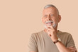 © Pixel-Shot - Portrait of senior man on beige background