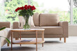 © Pixel-Shot - Vase with beautiful red roses on wooden coffee table in stylish living room