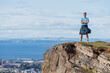 © Sergey Novikov - Highlander in kilt observes city of Edinburg and sea from cliff