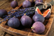 © Pixel-Shot - Board with fresh ripe figs and lavender flowers on wooden background, closeup