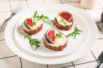 Wall Mural - Plate of sandwiches with fresh ripe fig on white checkered fabric as background, closeup