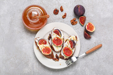 Wall Mural - Plate, sandwiches with fresh ripe fig and jar of honey on grey grunge background