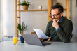 © NDABCREATIVITY - Business man accountant analyst holding documents, work at laptop computer doing online trade market