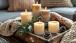 © Stamplovesink - Living room table decor for christmas with timber tray filled with lit candles and pine cones and leaves and cosy blankets and sofa behind