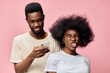 © SHOTPRIME STUDIO - A joyful young African couple poses against a pink background, showcasing vibrant emotions while enjoying their time together, highlighting modern fashion and diversity