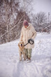 © StockMediaSeller - Elderly woman walking her Golden Retriever on a snowy path in the countryside. The woman looks down at her loyal dog with affection, enjoying a quiet winter day surrounded by snow and bare trees.