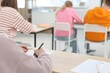 © New Africa - Students taking exam at wooden table indoors, selective focus